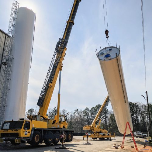 Standing silos using two cranes